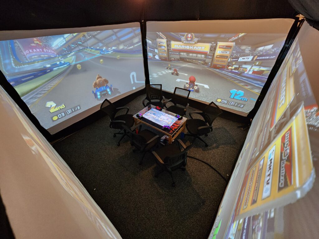 Multiplayer Mario Kart running in the LAIR where each player gets their own wall screen